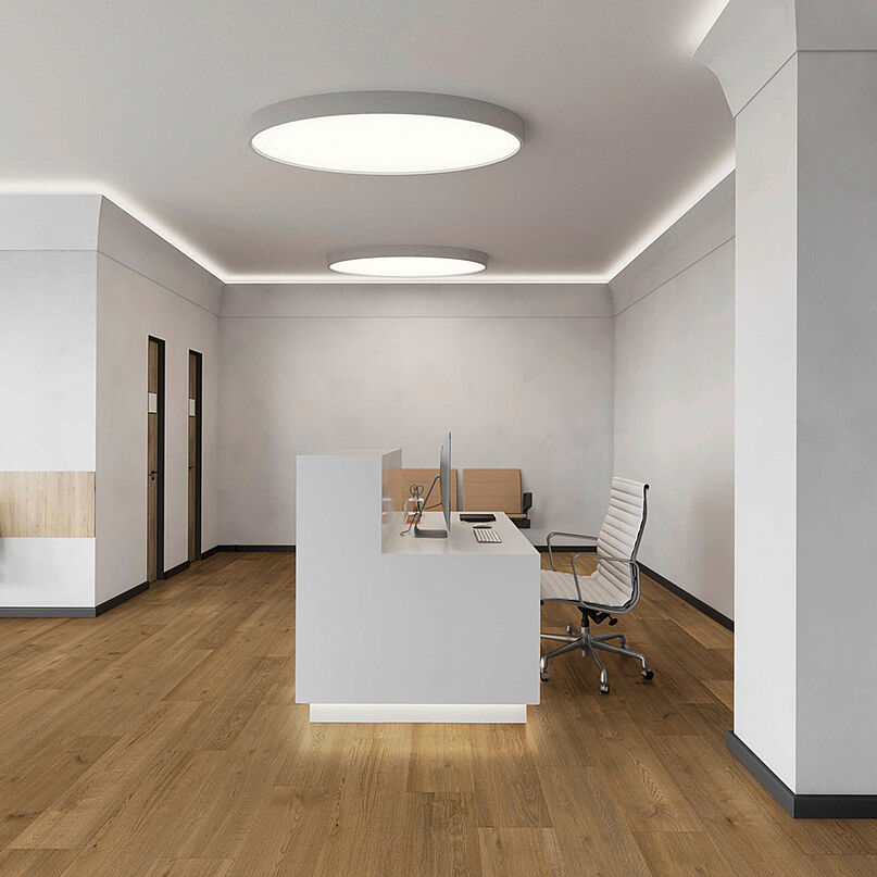 Bright reception with a counter and recycled elastic flooring in a natural, calm wood design. Modern reception area with recycled elastic flooring in warm wood-look.